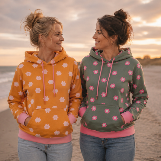 French Terry mit großen rosa Blüten auf senfgelbem oder salbeigrünem Hintergrund aus 95 % Baumwolle und 5 % Elasthan – ideal für Hoodies, Kinderkleidung und bequeme Freizeitmode.