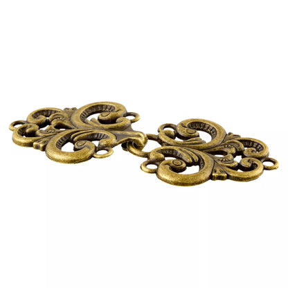 Schräge Ansicht des ornamentalen Metallverschlusses in Altmessing mit sichtbarem Haken und Ösen zum Annähen.
