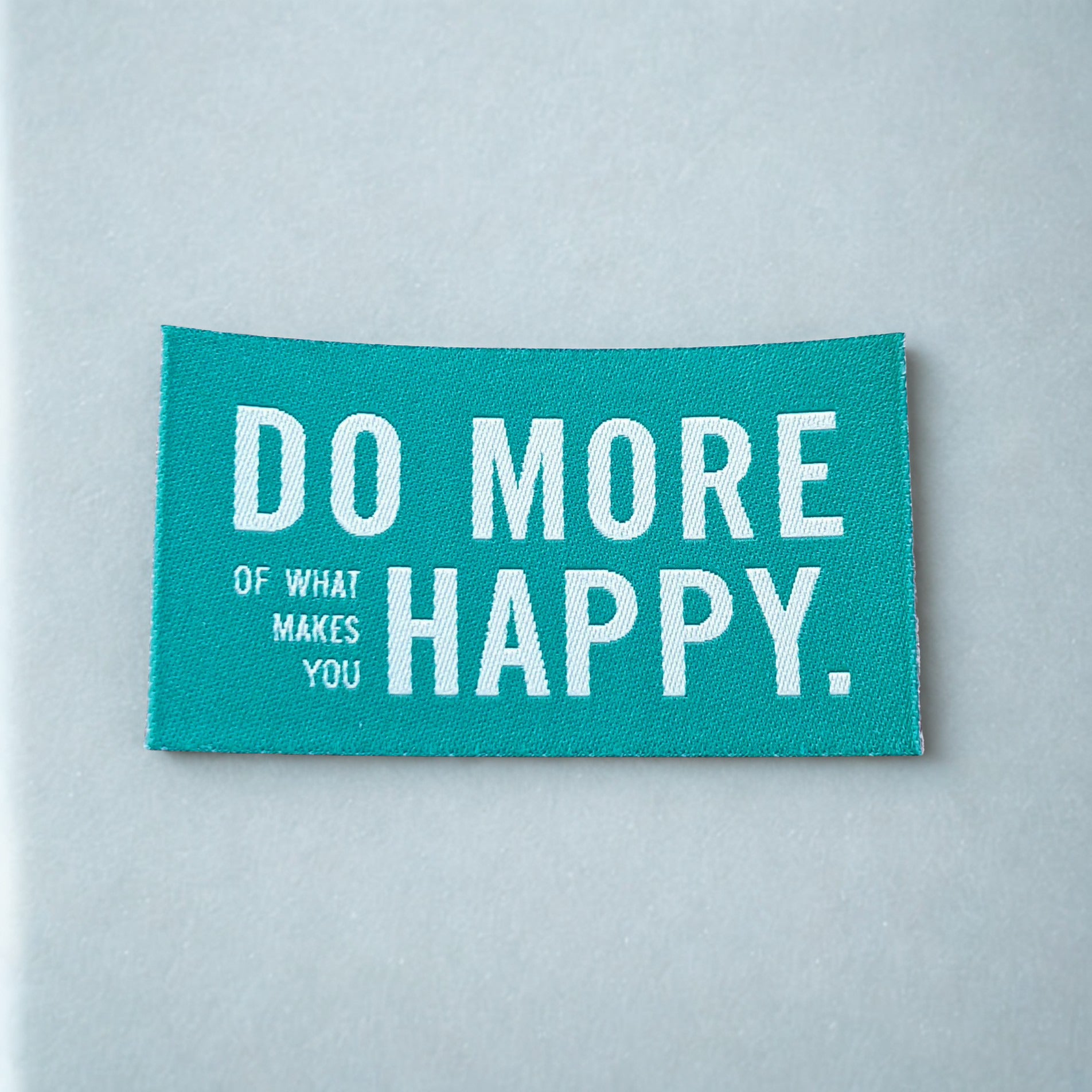 Aufbügelbare Weblabel von Prülla „Do more of what makes you happy“ in 4 Farben 4x7 cm